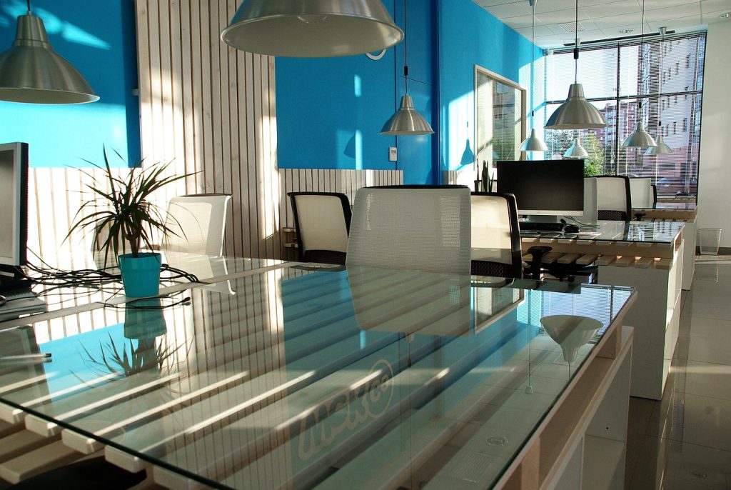 A glass table with a computer on its surface, highlighting a modern and minimalist workspace