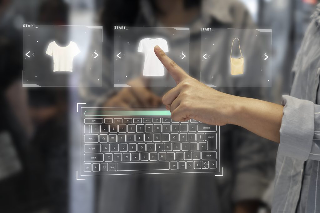 A person points at a virtual screen displaying various clothing items for selection or viewing
